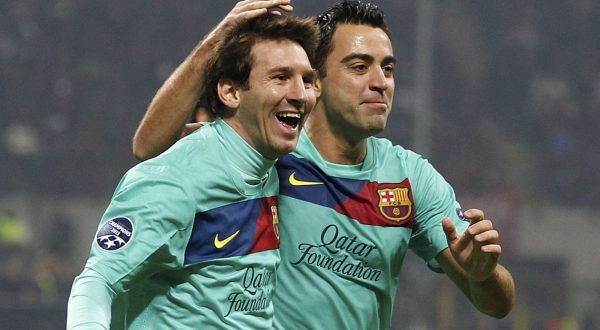 Barcelona forward Lionel Messi, of Argentina, left, celebrates with teammates midfielder Xavi Hernandez after an own goal of AC Milan midfielder Mark Van Bommel, during a Champions League, Group H soccer match between AC Milan and Barcelona at the San Siro stadium in Milan, Italy, Wednesday, Nov.23, 2011. (AP Photo/Luca Bruno)