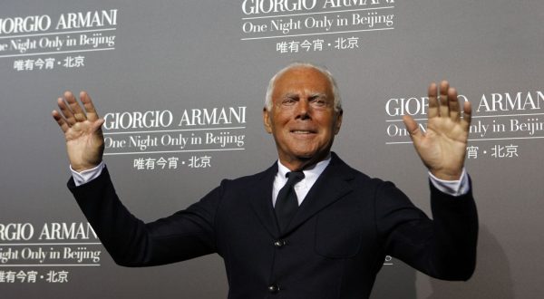 Designer Giorgio Armani gestures as he greets photographers before the start of his fashion show in Beijing, China, Thursday, May 31, 2012. (AP Photo/Ng Han Guan)