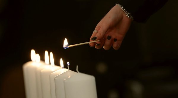 epa10578896 A person lights a candle during a special memorial service for victims of the Holocaust during the celebration of Yom HaShoah, the Israeli Holocaust Remembrance Day, at the Jewish Community Center in Bucharest, Romania, 18 April 2023. The Holocaust Remembrance Day 2023 began in the morning of 17 April and will end in the evening of 18 April, corresponding to the 27th day of Nisan on the Hebrew calendar, also marking the anniversary of the Warsaw Ghetto Uprising during World War II.  EPA/ROBERT GHEMENT
