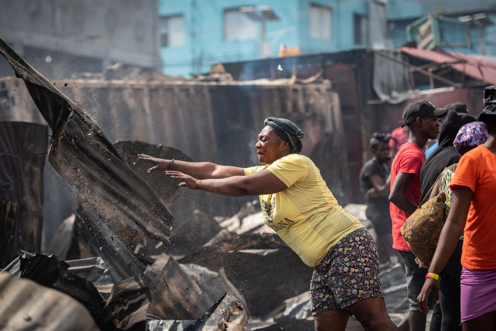 epa10608948 A woman removes remains of a fire in Port-au-Prince, Haiti, 04 May 2023. A huge fire occurred during the early hours of 04 May, in the market known as Shada, located in Petionville, destroyed a large amount of merchandise and food.  EPA/Johnson Sabin