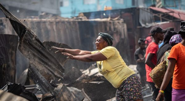 epa10608948 A woman removes remains of a fire in Port-au-Prince, Haiti, 04 May 2023. A huge fire occurred during the early hours of 04 May, in the market known as Shada, located in Petionville, destroyed a large amount of merchandise and food.  EPA/Johnson Sabin