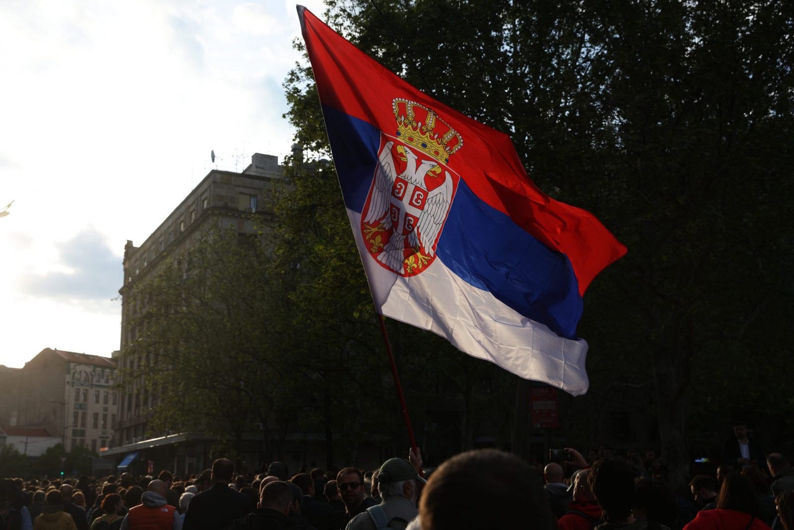 epa10615781 A man waves a Serbian flag during a protest in Belgrade, Serbia, 08 May 2023. Opposition political parties have called on a peaceful and silent protest against violence in Serbian society following two mass shootings.  EPA/ANDREJ CUKIC