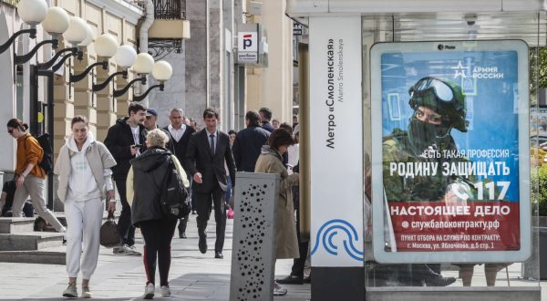 epa10623095 People walk past a poster with a proposal to serve on a contract in the Armed Forces of the Russian Federation in Moscow, Russia, 12 May 2023. On 24 February 2022 Russian troops entered Ukrainian territory in what the Russian president declared as a 'Special Military Operation', starting an armed conflict.  EPA/YURI KOCHETKOV