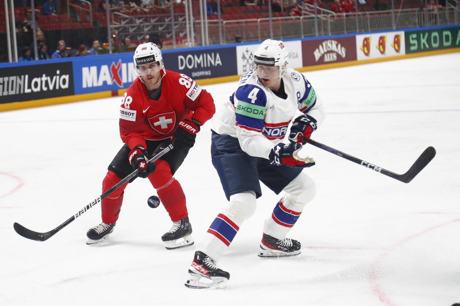 epa10627355 Johannes Johannesen (R) of Norway and Christoph Bertschy of Switzerland in action during the preliminary round group B match between Norway and Switzerland at the IIHF Ice Hockey World Championship 2023 in Arena Riga, Latvia, 14 May 2023.  EPA/TOMS KALNINS