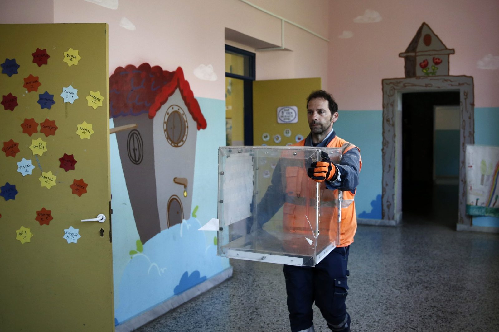 epa10638248 A municipality worker carries a ballot box at a primary school that will be used as a polling station, in Chalandri suburb north of Athens, Greece, 19 Μay 2023, ahead of the country’s parliamentary elections scheduled for 21 May 2023.  EPA/YANNIS KOLESIDIS