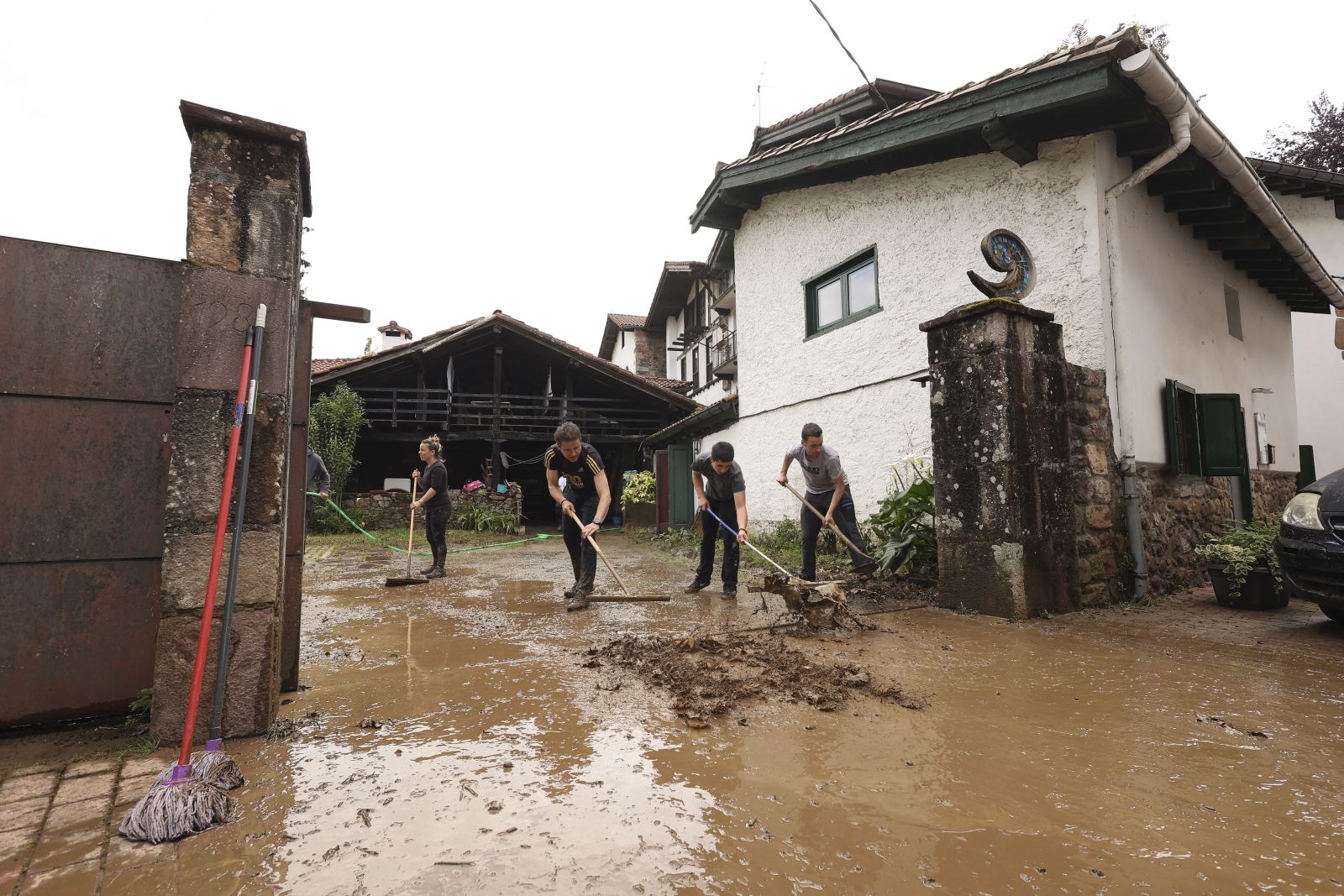 epa10640329 People clean the streets, houses and businesses of mud after floods registered in Bera in Navarra, Spain, 20 May 2023, after the river overflowed due to the heavy rains registered during the night and the early hours.  EPA/Villar Lopez