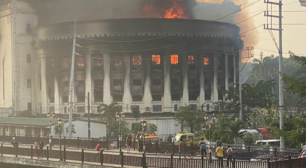 epa10645232 Flames and smoke rise from the burning Philippine Central Post Office building in Manila, Philippines, 22 May 2023. A massive fire hit the Central Post Office where the main mail sorting and distribution operations of the country are. Arson investigators are still conducting an investigation of the possible cause of the fire and extent of damage to the postal headquarters.  EPA/FRANCIS R. MALASIG