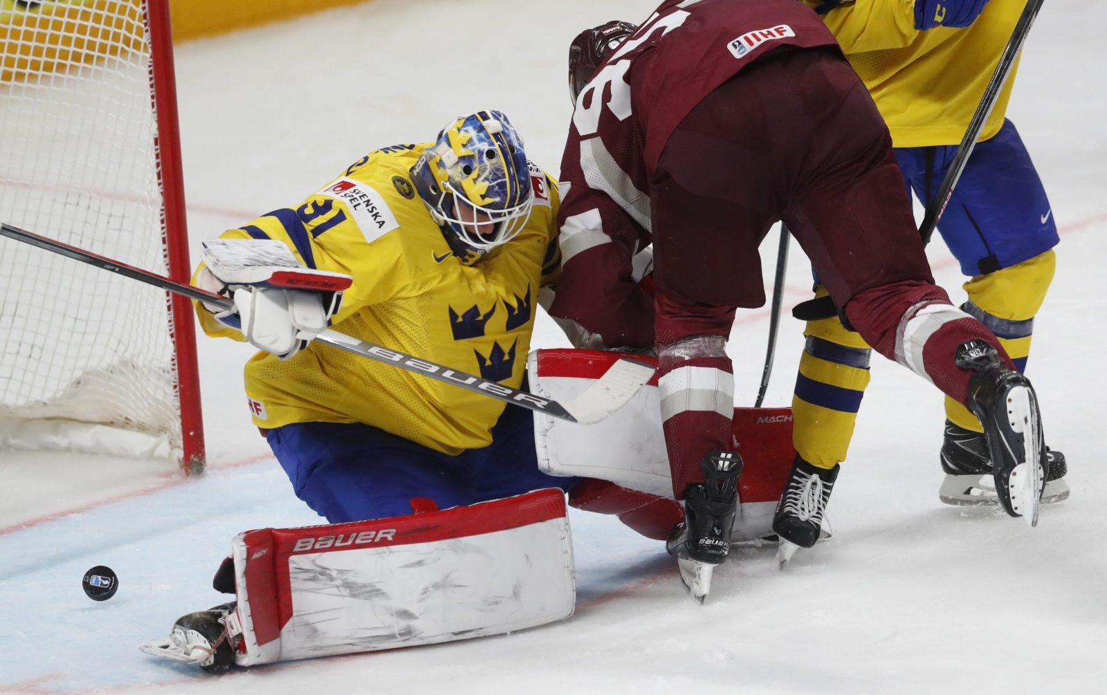 epa10654147 Goaltender Lars Johansson of Sweden in action with Oskars Batna of Latvia during the quarter final match between Sweden and Latvia at the IIHF Ice Hockey World Championship 2023 in Riga, Latvia, 25 May 2023.  EPA/TOMS KALNINS
