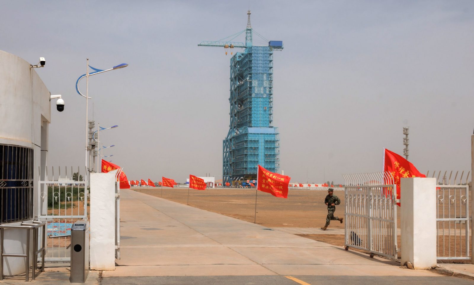 epa10661519 A member of People's Liberation Army (PLA) runs on the site of Shenzhou-16 manned space flight mission on the eve of launching in Jiuquan, Gansu province, China, 29 May 2023. The Shenzhou-16 manned space flight mission is expected to be launched on 30 May, and will transport three Chinese astronauts to the Tiangong space station.  EPA/ALEX PLAVEVSKI