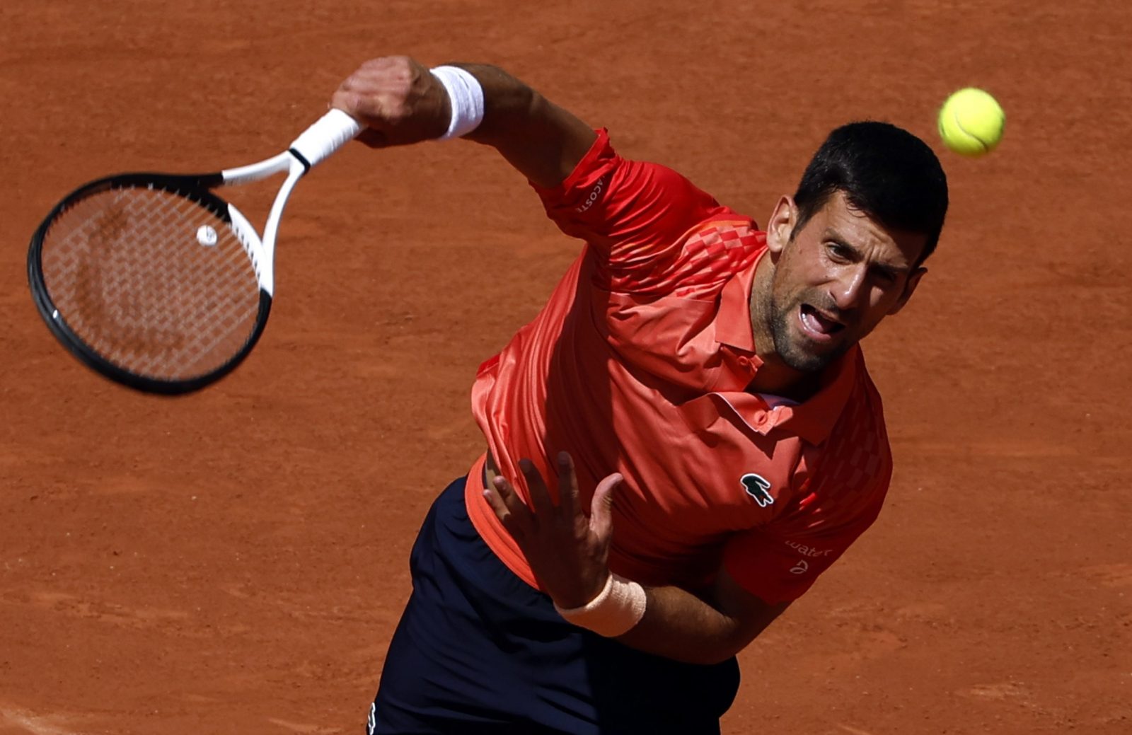 epa10661865 Novak Djokovic of Serbia serves to Aleksandar Kovacevic of the USA in their Men's Singles first round match during the French Open Grand Slam tennis tournament at Roland Garros in Paris, France, 29 May 2023.  EPA/YOAN VALAT