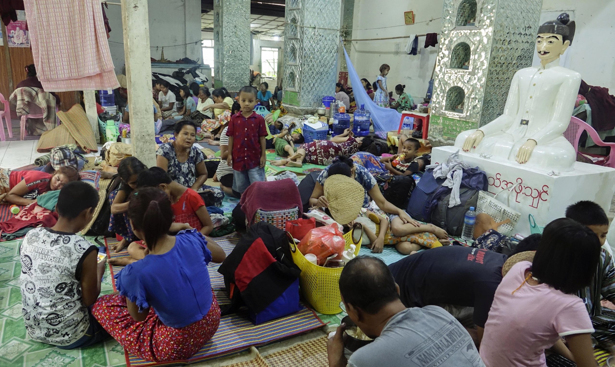 epa10624892 People gather at a monastery used as a temporary shelter in Sittwe, Rakhine State, Myanmar, 13 May 2023. A Very Severe Cyclonic Storm 'Mocha' formed at the Bay of Bengal and is expected to move towards Myanmar-Bangladesh border on 14 May, according to the Department of Meteorology and Hydrology in Myanmar.  EPA/NYUNT WIN