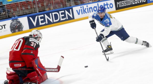 epa10634760 Mikhail Rakhmanov (R) of Kazakhstan in action against goaltender Joel Hofer of Canada during the preliminary round group B match between Canada and Kazakhstan at the IIHF Ice Hockey World Championship 2023 in Arena Riga, Latvia, 17 May 2023.  EPA/TOMS KALNINS