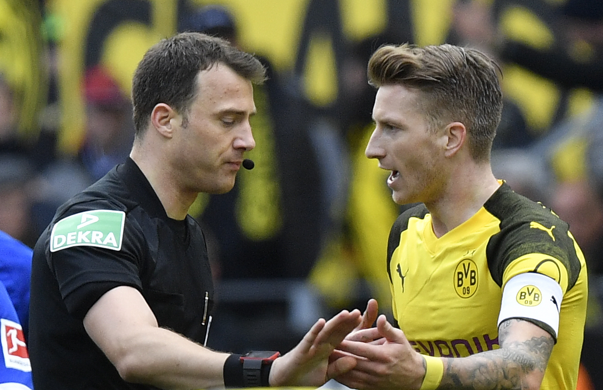 Referee Felix Zwayer talks to Dortmund's Marco Reus after he he gave him a red card during the German Bundesliga soccer match between Borussia Dortmund and FC Schalke 04 in Dortmund, Germany, Saturday, April 27, 2019. Dortmund was defeated in the Derby by Schalke with 2-4. (AP Photo/Martin Meissner)