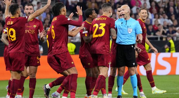 Roma players talk to Referee Anthony Taylor before he checks the VAR for a possible penalty during the Europa League final soccer match between Sevilla and Roma, at the Puskas Arena in Budapest, Hungary, Wednesday, May 31, 2023. (AP Photo/Petr David Josek)