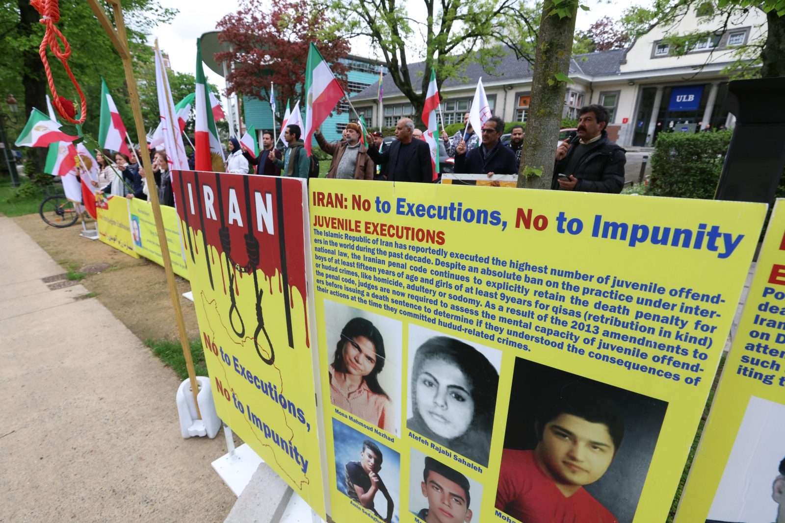 epa10623181 Representatives of opposition group the National Council of Resistance of Iran (NCRI) stand near a placard against executions in Iran during a protest in front of Iranian embassy in Brussels, Belgium, 12 May 2023. According to the NCRI, the protesters are demanding the closure of the Iranian embassy.  EPA/OLIVIER HOSLET