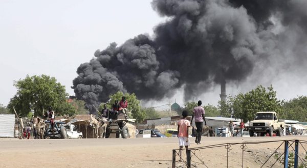 epa10625669 People drive as smoke rises from a fire at a market in the Upper Nile State town of Renk, South Sudan, 13 May 2023. According to UNHCR, at least 40,000 people have arrived into South Sudan since armed clashes between Sudan's military and rival paramilitary groups began in Khartoum and other parts of the country on 15 April 2023. Most of the refugees are part of the some 800,000 South Sudanese who had previously fled the war in South Sudan and who are now returning to a country with tensions still remaining in many areas, and more than two million internally displaced people. Upon arriving at the Joda border crossing, the refugees head to a transit area set up by UNHCR in the small town of Renk, where various UN agencies assist them with registration, food, health check and logistics.  EPA/AMEL PAIN