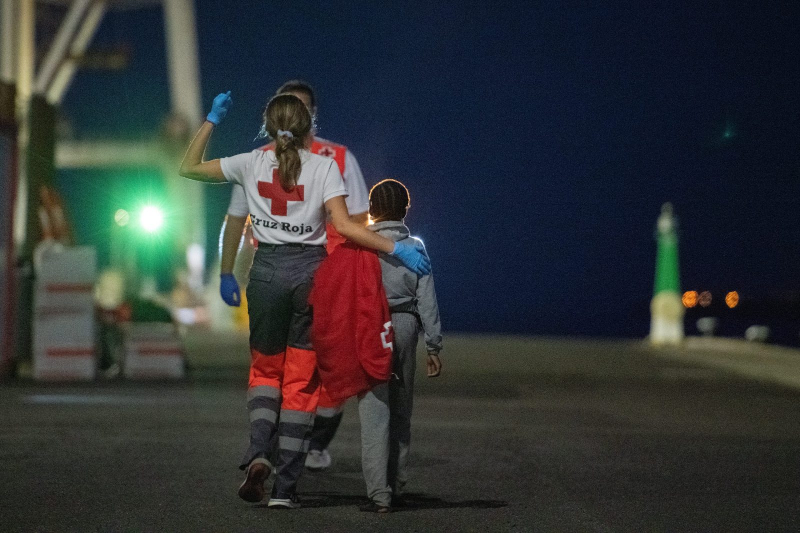 epa10675310 A Red Cross member takes care of a migrant girl after a Spanish sea rescue ship arrived in port with 57 migrants on board, at the port in Puerto del Rosario, Fuerteventura island, Canary Islands, southwestern Spain, late 05 June 2023 (issued on 06 June 2023). Spanish authorities rescued 57 migrants, including six women and a girl, found on board a boat off eastern Fuerteventura coast.  EPA/Carlos de Saa