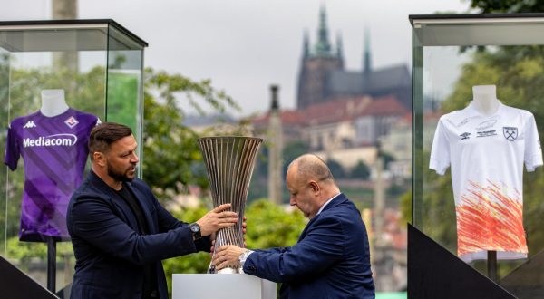 epa10675388 Former Fiorentina player Tomas Ujfalusi (L) and President of the Czech Republic's Football Association and member of the UEFA Executive Committee Petr Fousek (R) place a replica of the UEFA Conference League Trophy in Prague, Czech Republic, 06 June 2023. West Ham United will face Fiorentina in the UEFA Conference League final in Prague on 07 June 2023.  EPA/MARTIN DIVISEK