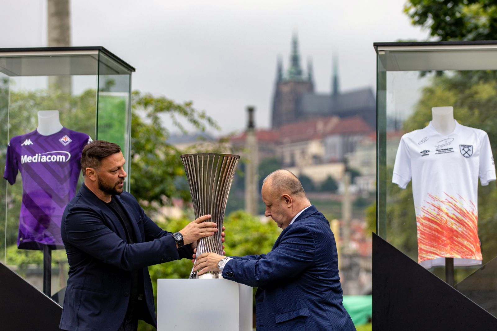 epa10675388 Former Fiorentina player Tomas Ujfalusi (L) and President of the Czech Republic's Football Association and member of the UEFA Executive Committee Petr Fousek (R) place a replica of the UEFA Conference League Trophy in Prague, Czech Republic, 06 June 2023. West Ham United will face Fiorentina in the UEFA Conference League final in Prague on 07 June 2023.  EPA/MARTIN DIVISEK
