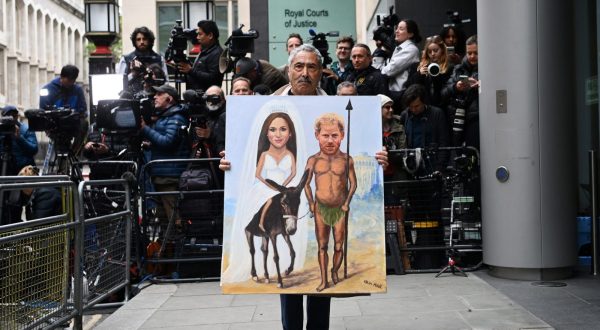 epa10675524 Political satire artist Kaya Mar holds his painting showing Britain's Prince Harry and Meghan ahead of Prince Harry's arrival at the High Court in London, Britain, 06 June 2023. Prince Harry is to give evidence over the phone hacking trial against the Mirror Group Newspapers. Harry is seeking damages against the Daily Mirror over unlawful information gathering through phone hacking.  EPA/ANDY RAIN