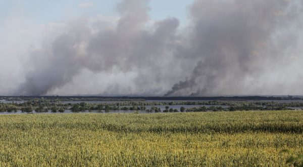 epa10680415 Smoke rises in the distance following shelling beyond the destroyed Antonivsky Bridge in the Kherson region, Ukraine, 08 June 2023. Ukraine has accused Russian forces of destroying a critical dam and hydroelectric power plant on the Dnipro River in the Kherson region along the front line in southern Ukraine on 06 June, leading to the flooding of a number of settlements.  EPA/MYKOLA TYMCHENKO