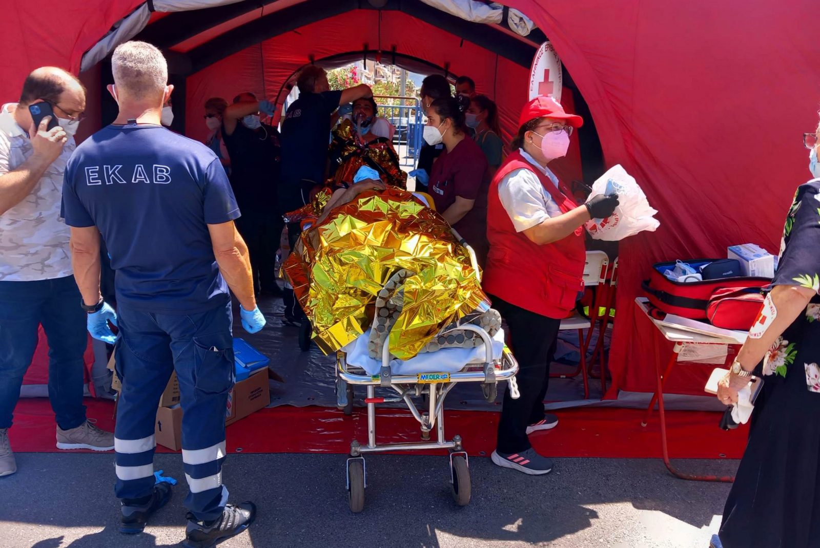 epa10690158 Paramedics of the Greek National Emergency Ambulance Service (EKAV) and members of the Greek Red Cross helps migrants upon arrival to the Kalamata's port, Greece, 14 June 2023. The bodies of at least 32 individuals were recovered, while 104 people were rescued by the Coast Guard after a fishing boat with an unidentified number of undocumented migrants on board capsized in international waters on 14 June, about 47 nautical miles southwest of Pylos in the Peloponnese. Four foreign nationals were transferred with a super puma helicopter to the hospital of Kalamata. The other rescued migrants are expected to be taken to the port of Kalamata, where preparations for their reception have been made with the assistance of the general secretariat of Civil Protection. Two coast guard patrol vessels,  a Greek Navy frigate, seven vessels that were sailing nearby, a Greek Navy helicopter and a drone continued to search for survivors.  EPA/BOUGIOTIS EVANGELOS