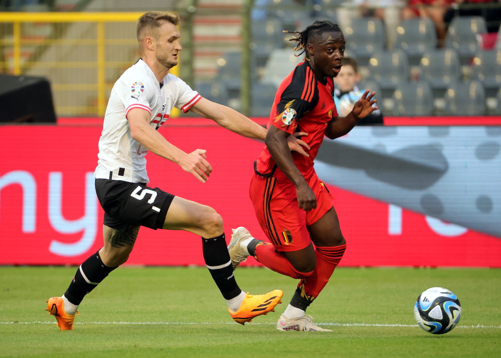 epa10697167 Jeremy Doku (R) of Belgium and Stefan Posch (L) of Austria in action during the UEFA EURO 2024 qualifying match between Belgium and Austria, in Brussels, Belgium, 17 June 2023.  EPA/OLIVIER MATTHYS