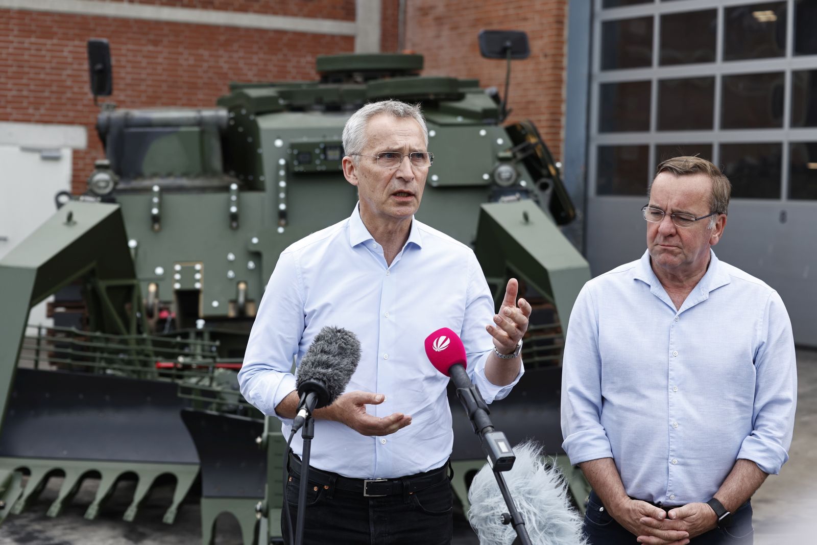 epa10701739 NATO Secretary General Jens Stoltenberg (L) and German Defence Minister Boris Pistorius speak to the media while standing in front of a mine clearance tank Wisent at FFG Flensburger Fahrzeugbau Gesellschaft in Flensburg, Germany, 20 June 2023 . FFG is a private company that is refurbishing Leopard 1 tanks that are being donated by NATO member countries to Ukraine.  EPA/MORRIS MACMATZEN / POOL