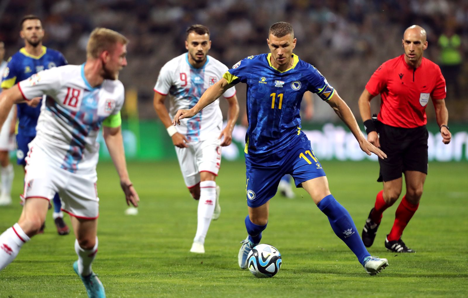 epa10702576 Edin Dzeko (R) of Bosnia and Herzegovina in action against Luxembourg player Laurent Jans (L) and Danel Sinani (C) during the UEFA EURO 2024 qualifying soccer match between Bosnia & Herzegovina and Luxembourg in Zenica, Bosnia and Hercegovina, 20 June 2023.  EPA/FEHIM DEMIR