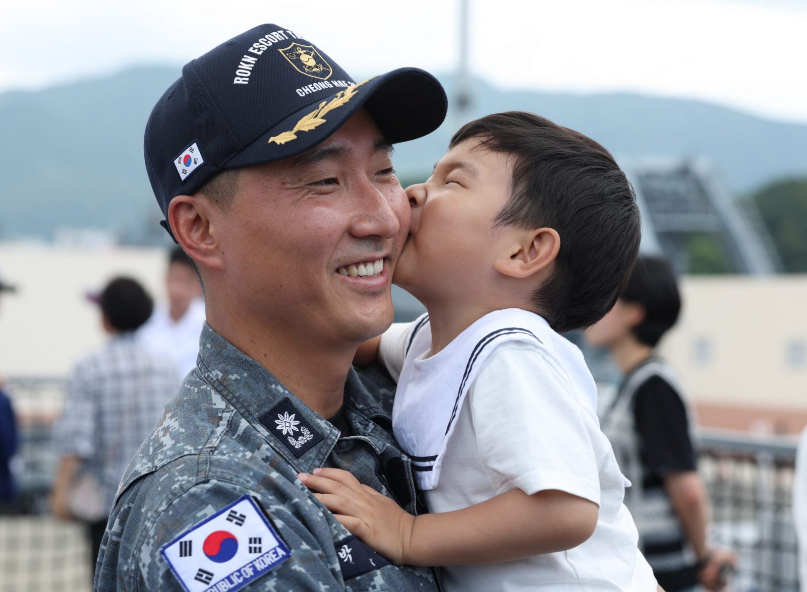 epa10704963 A naval officer is reunited with his son after returning from a six-month anti-piracy operation in waters off Somalia and the Strait of Hormuz during a ceremony to welcome the return of the 300-strong 38th contingent of the Cheonghae Unit at a naval base in Changwon, South Korea 22 June 2023.  EPA/YONHAP SOUTH KOREA OUT