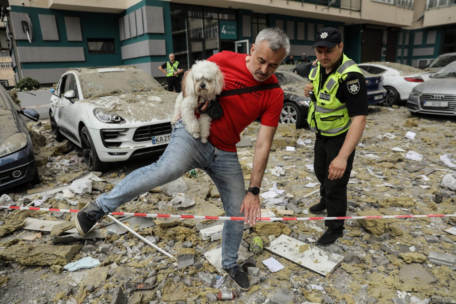 epa10709063 A local resident carries his dog as he leaves the area after an apartment block was damaged by rocket fragments in Kyiv (Kiev), Ukraine, 24 June 2023, amid the Russian invasion. At least three people were killed by rocket fragments hitting a high-rise building in the capital’s Solomyan district, Kyiv Mayor Vitali Klitschko confirmed. According to the Ukrainian Air Force, Russia fired 41 missiles and one shock drone on Ukraine. All air targets were shot down.  EPA/OLEG PETRASYUK