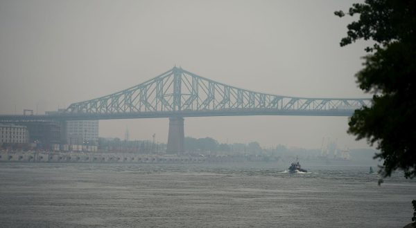 epa10712294 A view of the Jacques Cartier Bridge crossing the Saint Lawrence River shrouded in haze of smog, in Montreal, Canada, 26 June 2023. A smog warning was issued for Montreal and surrounding area on 26 June morning as the city's Air Quality Health Index (AQHI) remained at 'high risk', according to Environment and Climate Change Canada (ECCC). The smog is a product of a number of wildfires currently burning in northern Quebec, with winds blanketing parts of the Canadian province in smoke.  EPA/ANDRE PICHETTE