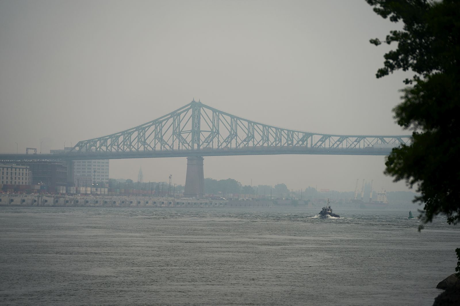 epa10712294 A view of the Jacques Cartier Bridge crossing the Saint Lawrence River shrouded in haze of smog, in Montreal, Canada, 26 June 2023. A smog warning was issued for Montreal and surrounding area on 26 June morning as the city's Air Quality Health Index (AQHI) remained at 'high risk', according to Environment and Climate Change Canada (ECCC). The smog is a product of a number of wildfires currently burning in northern Quebec, with winds blanketing parts of the Canadian province in smoke.  EPA/ANDRE PICHETTE