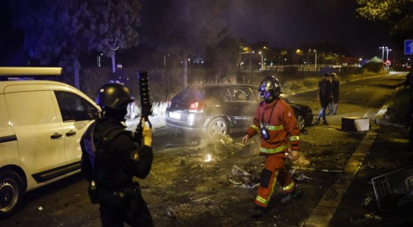 epaselect epa10716062 French firefighter and French riot Police officer walk near a garbage fire in Nanterre, near Paris, France, 28 June 2023. The violence broke out after police fatally shot a 17-year-old during a traffic stop in Nanterre. According to the French interior minister, 31 people were arrested with 2,000 officers being deployed to prevent further violence.  EPA/YOAN VALAT