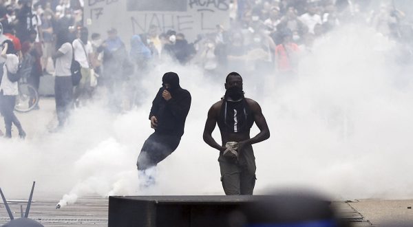 epa10717580 Protesters stand amid tear gas during clashes with French riot police following a march in the memory of 17-year-old Nahel, who was killed by French Police in Nanterre, near Paris, France, 29 June 2023. Violence broke out after the police fatally shot a 17-year-old during a traffic stop in Nanterre on 27 June. According to the French interior minister, 31 people were arrested with 2,000 officers being deployed to prevent further violence.  EPA/YOAN VALAT