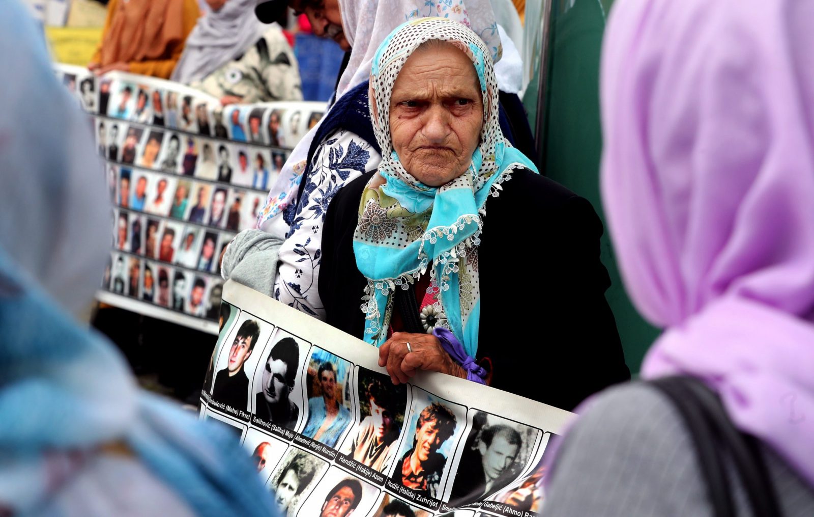 epa10685031 Women from Srebrenica hold banners showing pictures of the 1995 Srebrenica massacre, during a peaceful demonstration at Alija Izetbegovic Square in Zenica, Bosnia and Herzegovina, 11 June 2023. More than 8,000 Muslim men and boys were executed in July 1995 after Bosnian Serb forces overran the town of Srebrenica during the Bosnian War. The protest takes place every 11th of the month across different cities of Bosnia and Herzegovina.  EPA/FEHIM DEMIR
