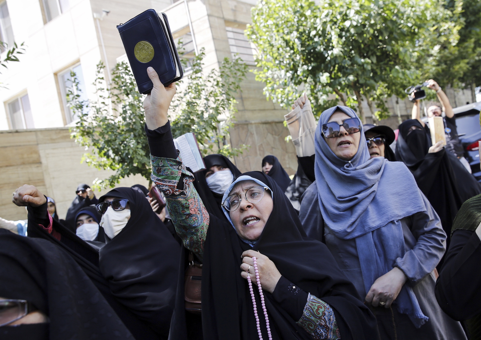 epa10719171 Iranian women hold copies of the holy book of Koran and shout slogans as they demonstrate in front of the Swedish embassy in Tehran, Iran, 30 June 2023. Iran's Foreign Ministry has summoned Sweden's charge d'affaires in Tehran, following the burning of a copy of the Koran by an Iraqi man outside a mosque in Stockholm on 28 June.  EPA/ABEDIN TAHERKENAREH