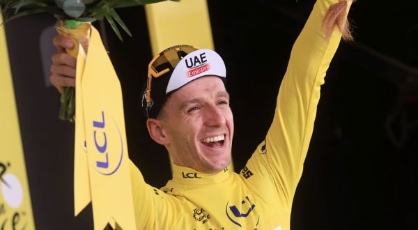 epa10721025 British rider Adam Yates of team UAE Team Emirates celebrates on the podium while wearing the overall leader's yellow jersey after winning the first stage of the Tour de France 2023, a 182km race with start and finish in Bilbao, Spain, 01 July 2023.  EPA/CHRISTOPHE PETIT TESSON