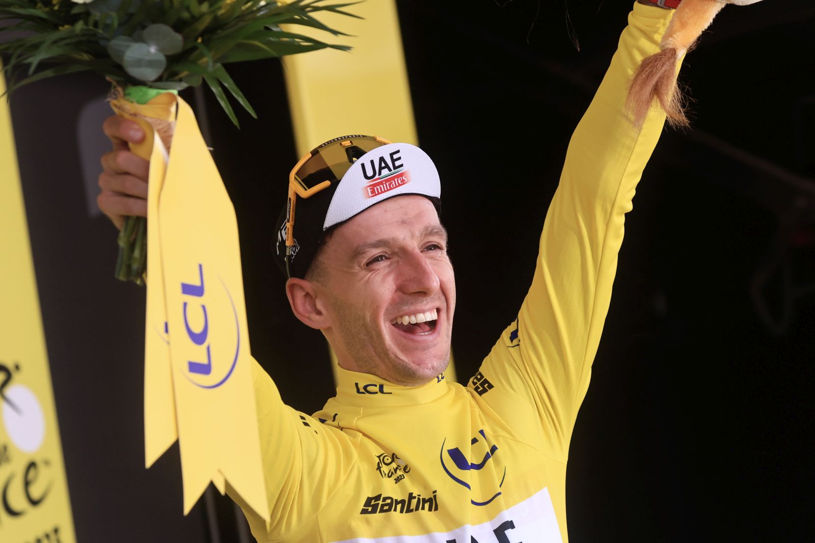 epa10721025 British rider Adam Yates of team UAE Team Emirates celebrates on the podium while wearing the overall leader's yellow jersey after winning the first stage of the Tour de France 2023, a 182km race with start and finish in Bilbao, Spain, 01 July 2023.  EPA/CHRISTOPHE PETIT TESSON
