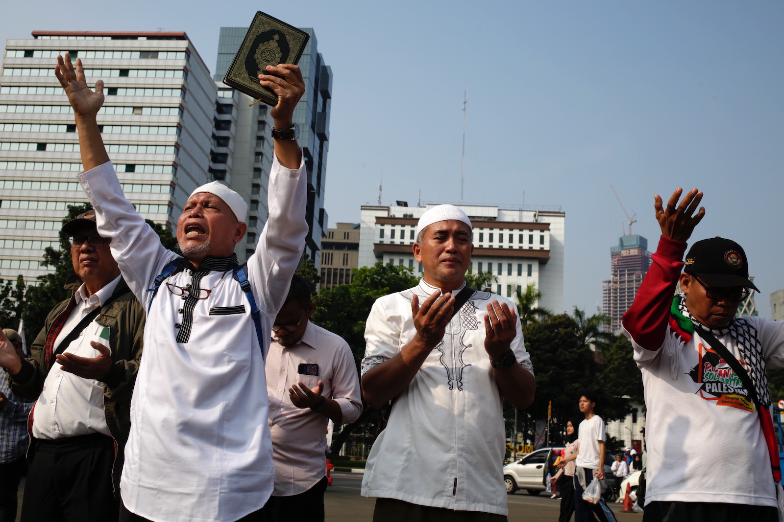 epa10721801 Indonesian muslim protestors shout slogans as they hold copies of the Koran during a protest in Jakarta, Indonesia, 02 July 2023. Dozens of muslim activists in Jakarta staged a protest against Sweden for allowing a protestor to burn a copy of the Koran outside of a mosque in Stockholm.  EPA/ADI WEDA