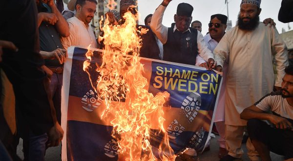 epa10722737 Demonstrators burn a mock Swedish flag as they attend a protest against the burning of a copy of the Koran in Sweden, in Karachi, Pakistan, 02 July 2023. Muslim activists staged protests across Pakistan against Sweden for allowing an Iraqi man to burn a copy of the Koran outside of a mosque in Stockholm.  EPA/SHAHZAIB AKBER