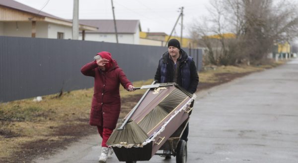 epa10731596 (FILE) -  Locals carry a coffin as the city was hit by shelling in the small city of Borodyanka near Kiev, Ukraine, 03 March 2022. Russian troops entered Ukraine on 24 February prompting the country's president to declare martial law.  EPA/ALISA YAKUBOVYCH