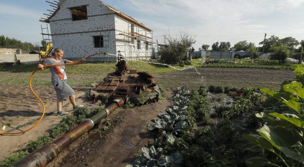 epa10734045 Yulia Semynog waters vegetables next to the remains of a Russian tank in the garden near her home at the village of Velyka Dymerka, Kyiv region, Ukraine, 05 July 2023 (issued 08 July 2023). Valeriy and Yulia Semynog, together with their three children, left their home when Russian troops arrived at Velyka Dymerka in March 2022. The family returned to their village only after Russian troops were pushed out from the Kyiv region in April 2022. They found their home destroyed along with the wreckage of a Russian tank in the garden. The locals planted flowers and vegetables between and around the wreckage of the tank. Velyka Dymerka as well as other towns and villages in the northern part of the Kyiv region, had become battlefields, heavily shelled, causing death and damage when Russian troops tried to reach the Ukrainian capital of Kyiv in February and March 2022.The war in Ukraine, marks on 08 July its 500th day.  According to the UN more than 9000 civilians have been killed since the war started.  EPA/SERGEY DOLZHENKO