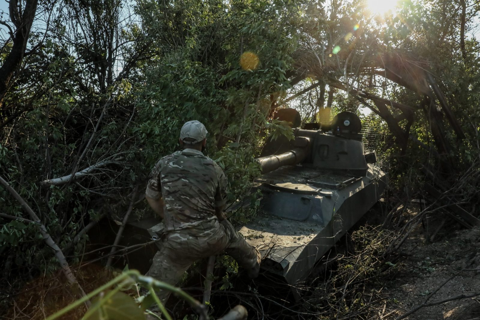 epa10744388 A Ukrainian serviceman of the 24th Separate Mechanized Brigade named after 'King Danylo' puts camouflage on a 2S1 Gvozdika self-propelled howitzer at an undisclosed location in the Donetsk region, eastern Ukraine, 13 July 2023, amid the Russian invasion. Russian troops entered Ukraine on 24 February 2022, starting a conflict that has provoked destruction and a humanitarian crisis.  EPA/OLEG PETRASYUK