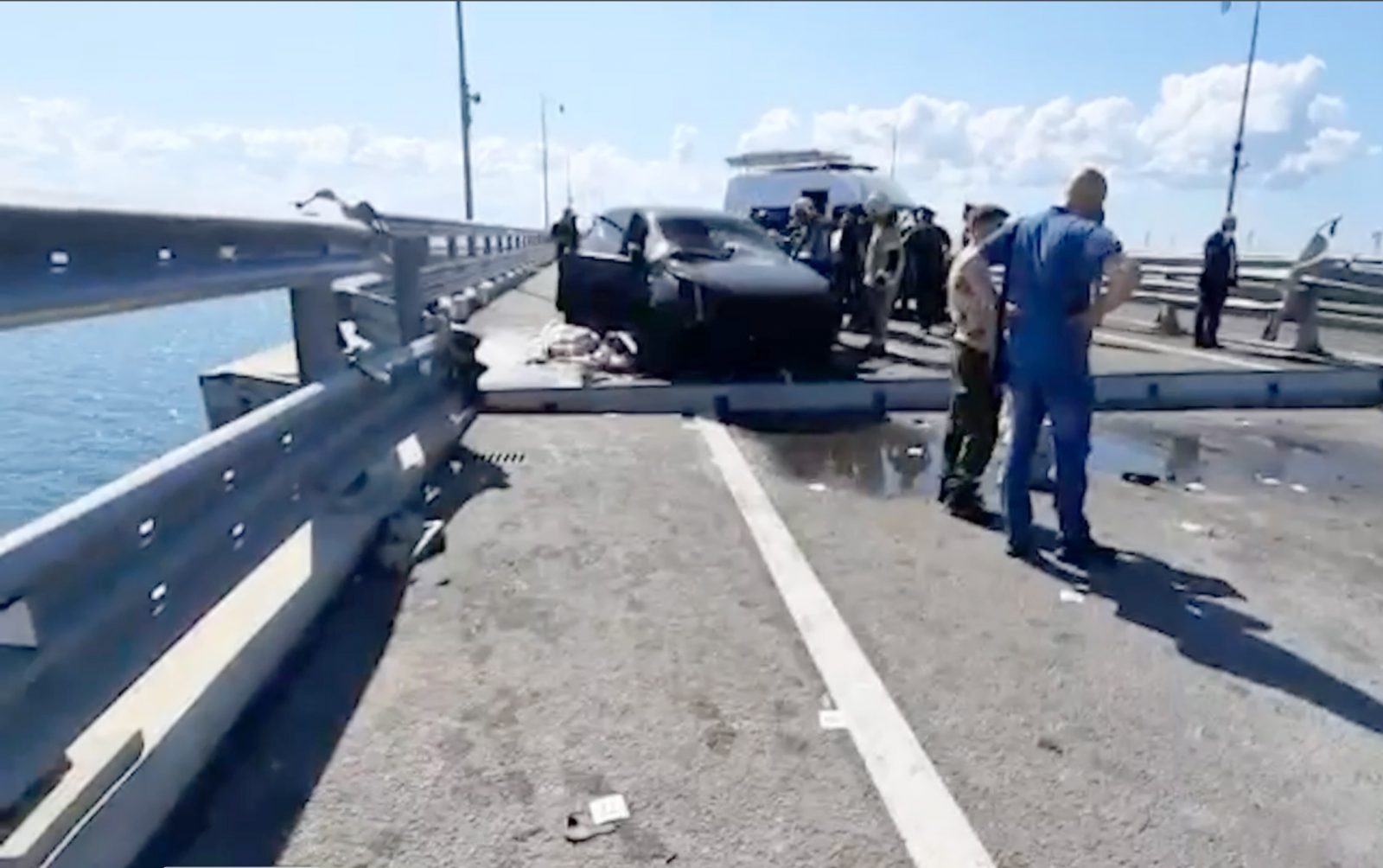 epa10751241 A still image taken from a handout video made available by Russia's Investigative Committee shows Russian Investigative Committee officers examining the damage on the Kerch Bridge connecting Crimea to mainland Russia, 17 July 2023. The Investigative Committee of Russia said that one of the sections of the Crimean bridge was damaged in the night of 16 to 17 July. Two civilians, a man and a woman, were killed while driving a car across the bridge; their minor daughter was injured in the incident, the statement added. Russia has blamed 'special services of Ukraine' for the 'attack', and said it launched a criminal investigation into the incident.  EPA/INVESTIGATIVE COMMITTEE OF THE RUSSIAN FEDERATION -- BEST QUALITY AVAILABLE -- MANDATORY CREDIT -- HANDOUT EDITORIAL USE ONLY/NO SALES