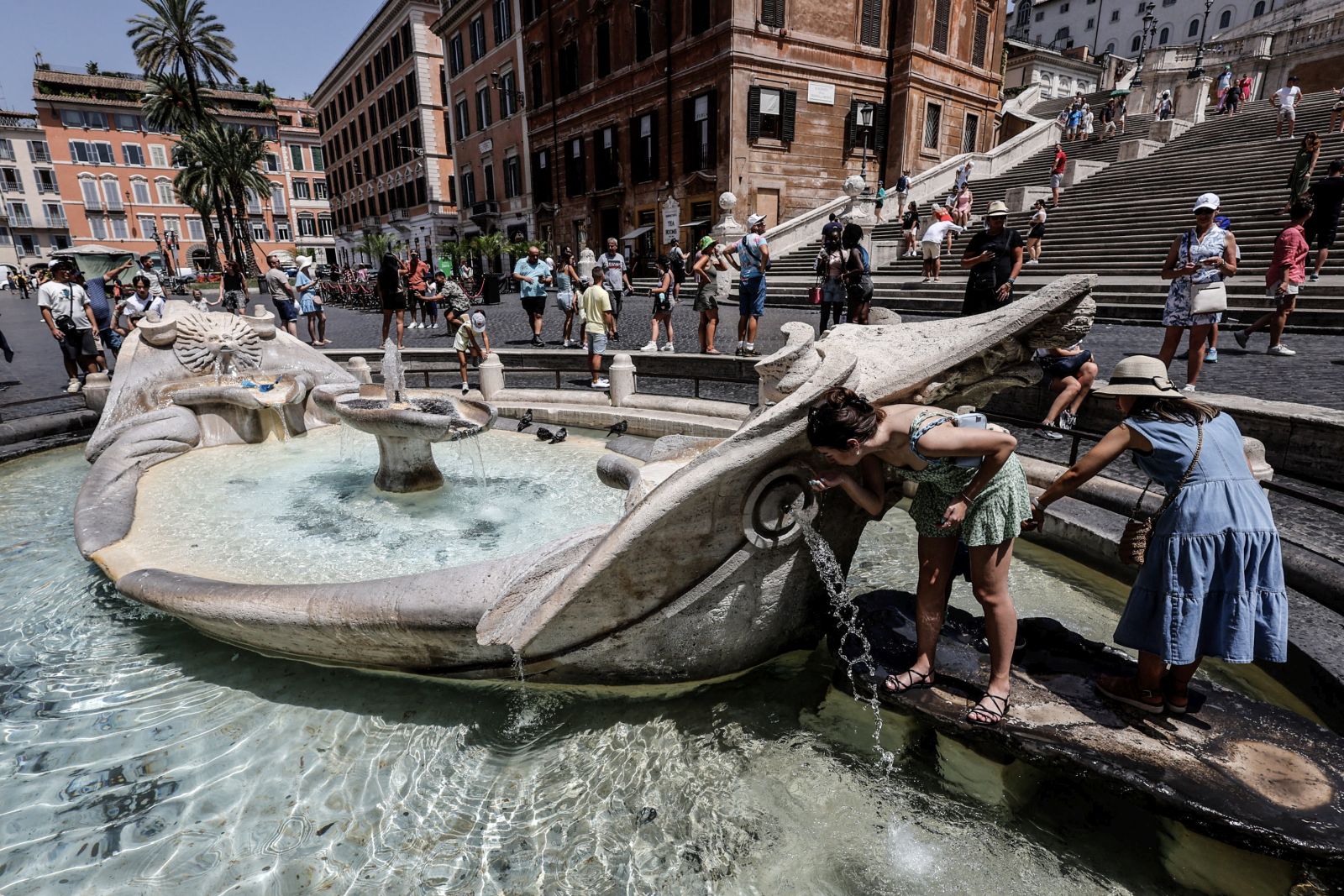 epa10751460 People cool off around a water fountain amid high temperatures, in Rome, Italy, 17 July 2023. Southern Europe is experiencing a major heat wave this week with temperatures expected to climb up to 48 Celsius degrees on the islands of Sicily and Sardinia. Italy's health ministry sent on 17 July a circular letter to the country's regional governments with a series of recommendations to manage the impact of the intense heat wave the country is enduring. These recommendations include setting up a 'heat code' at emergency rooms with special, priority procedures for people suffering heat-related health issues.  EPA/GIUSEPPE LAMI