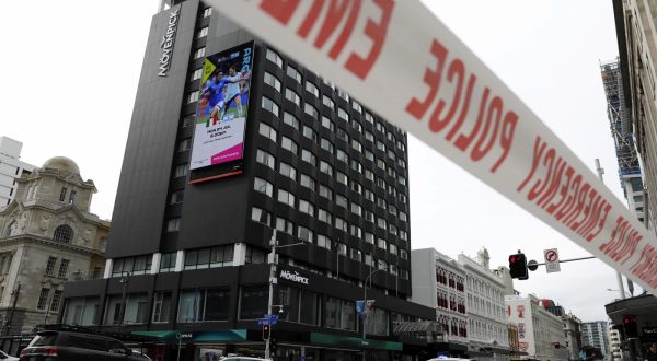 epaselect epa10756608 A digital display (top left) announcing a FIFA Women's World Cup fixture is seen as police block an area near the site of a shooting in Queen Street, Auckland, New Zealand, 20 July 2023. New Zealand Prime Minister Chris Hipkins confirmed in a press conference that a gunman killed two and injured six people, before being killed. The FIFA Women's World Cup is beginning on 20 July.  EPA/HOW HWEE YOUNG