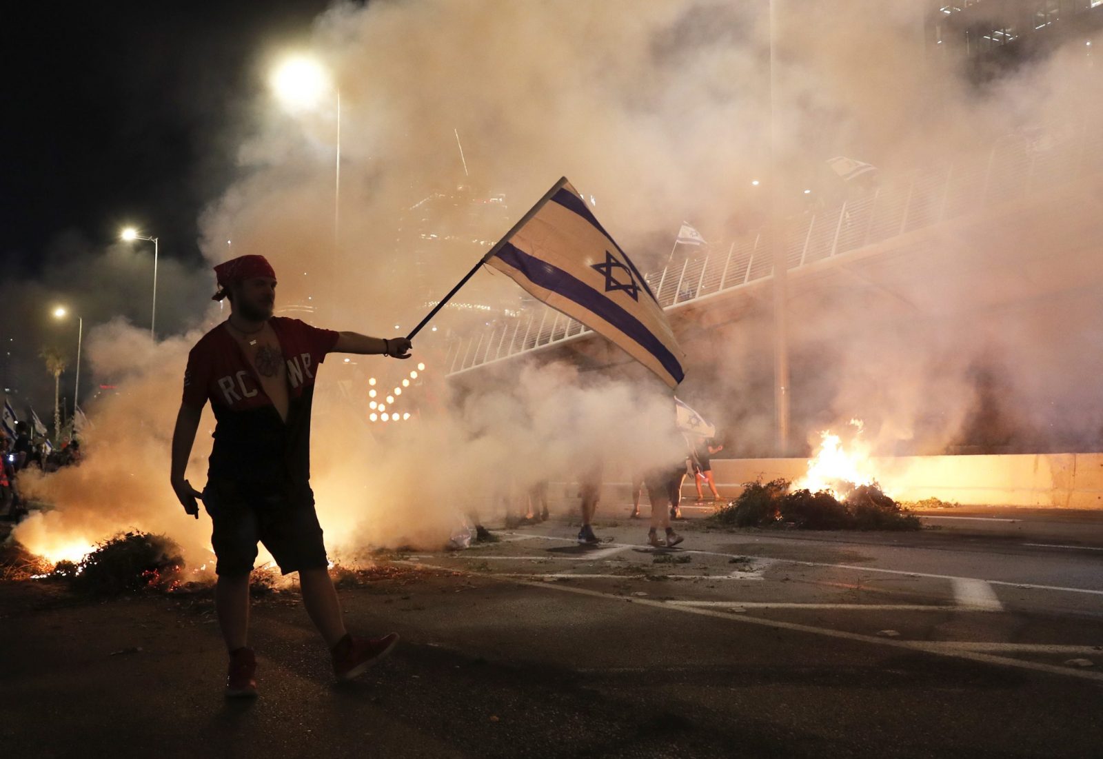epa10758818 Anti-government protesters burn barricades as they block Ayalon highway during a protest against the Israeli justice system reform in Tel Aviv, Israel, 20 July 2023. Protesters called for a new 'night of resistance' all around the country, in response to the Israeli government plans to pass an unpopular justice reform, which the protesters fear will weaken the independence of the Israeli Supreme Court.  In the absence of a constitution for the state of Israel, the Supreme Court plays a major role in maintaining the checks and balances between the legislative, the judiciary and the executive bodies of the state.  EPA/ATEF SAFADI