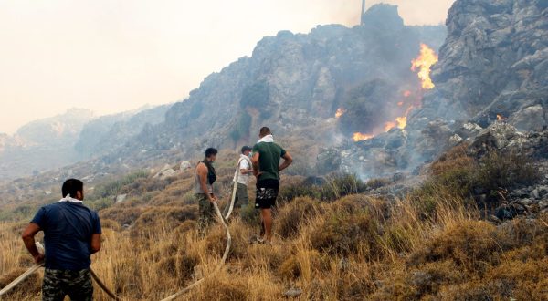 epa10762697 Volunteers try to put out a wildfire  in Kiotari village, on Rhodes island, Greece 22 July 2023. Although the Fire Department had managed to put out several rekindled blazes on the island over the last few days, the wildfire near the village of Laerma in the island's north keeps expanding and moving eastwards to the Gadoura dam, while residents in the villages of Lardos and Pilonas were told to evacuated their homes on the day, via the emergency number 112. Some 173 firefighters with 35 fire engines and 10 ground teams are battling the blaze, assisted by 3 water bombers and 2 helicopters. Another 31 firefighters with 4 fire engines and 3 ground teams were also expected to arrive from Slovakia. Local authority water tanks are also helping out.  EPA/DAMIANIDIS LEFTERIS