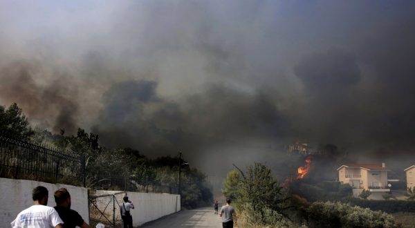 epa10769967 Residents wach a fire which broke out in the north part of the town of Lamia, in forested land with low-growing vegetation, Lamia, Greece 26 July 2023. The fire spread rapidly as strong winds were blowing in the area and drove the flames towards an inhabited area. An evacuation of houses in the area of Afanou was immediately decided, while two PZL firefighting aircraft started operating in the area. Strong firefighting forces were sent to the site, along with volunteers and municipality machinery and water trucks.  EPA/ARIS MARTAKOS